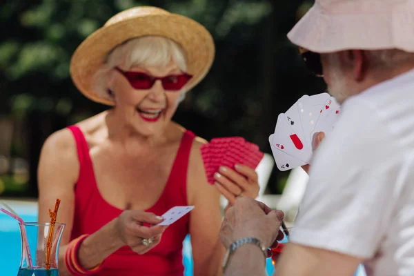Pensiunan pria berjanggut mengenakan kemeja putih bermain kartu dengan istri — Stok Foto