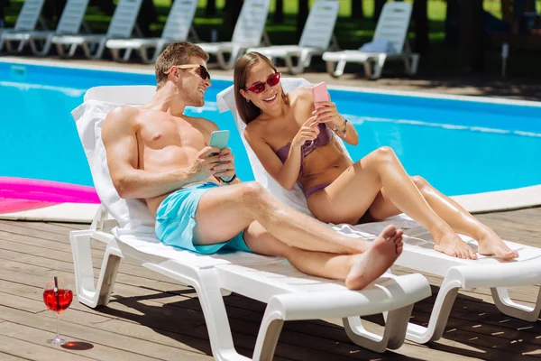 Beaming beautiful girlfriend showing photos her boyfriend — Stock Photo, Image