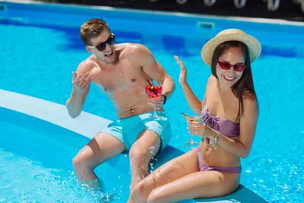 Femme élégante aux cheveux foncés se sentant froide tout en essayant l'eau de la piscine — Photo