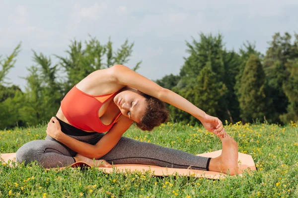 Dark-haired woman wearing leggings practicing yoga asana