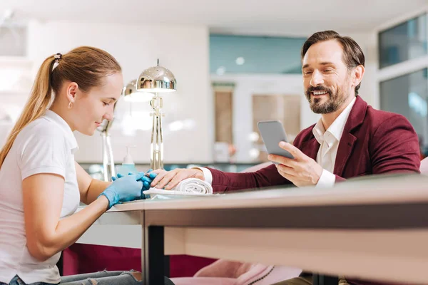 Positive female manicurist providing manicure — Stock Photo, Image