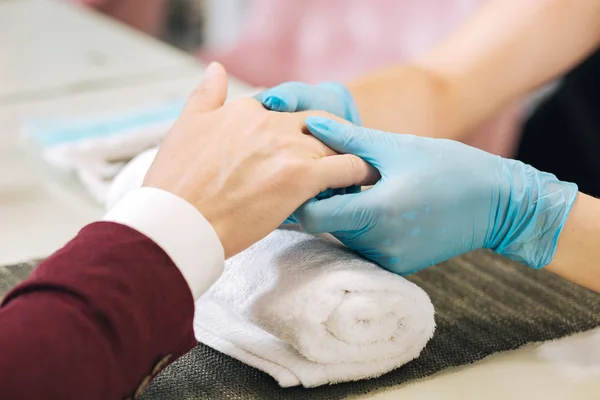 Female hands moisturizing male hands — Stock Photo, Image