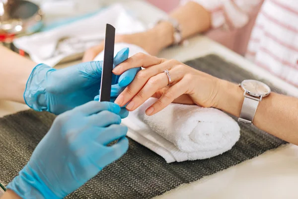 Manos femeninas puliendo uñas femeninas —  Fotos de Stock