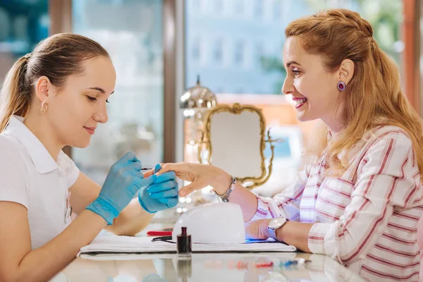 Determined female manicurist applying another coat — Stock Photo, Image