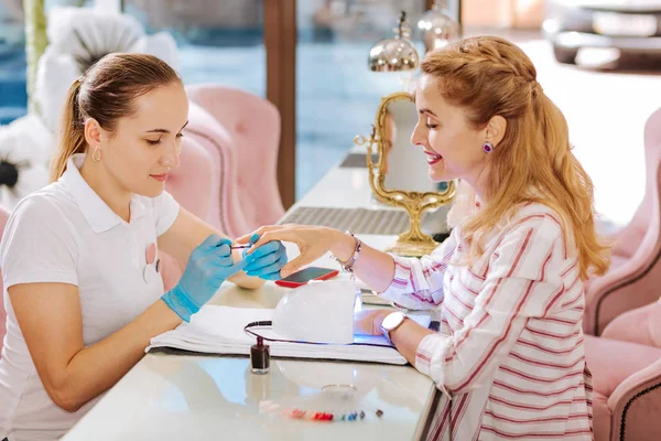 Diligent female manicurist using nail polish — Stock Photo, Image