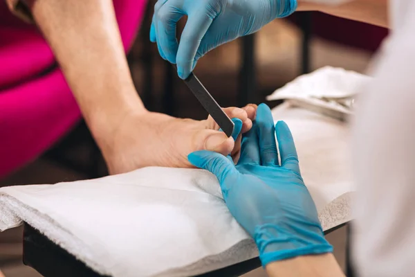 Female manicurist shaping nails on foot — Stock Photo, Image