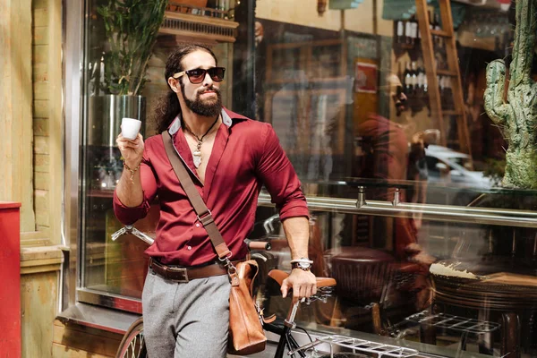 Красивый стильный мужчина, стоящий рядом с велосипедом — стоковое фото