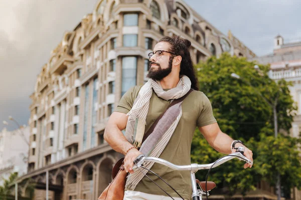 Homem adulto agradável segurando sua bicicleta — Fotografia de Stock