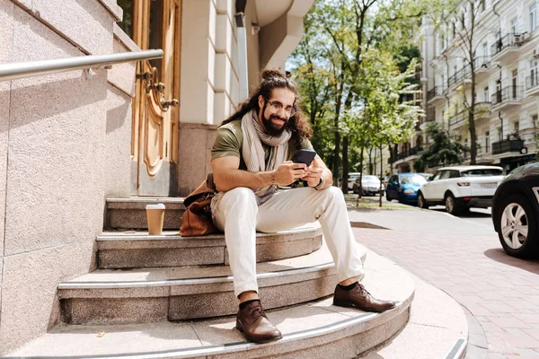 Encantado homem bonito digitando uma mensagem — Fotografia de Stock