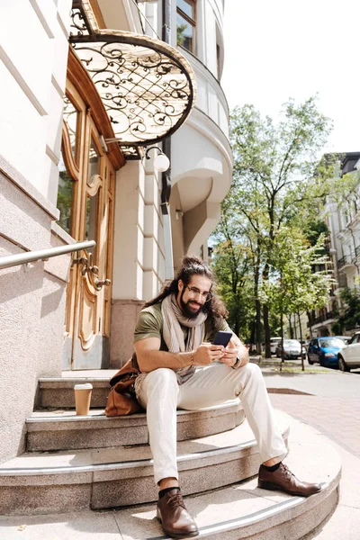 Merdivenlerde oturan mutlu neşeli adam — Stok fotoğraf