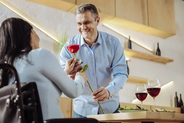 Mujer alegre recibiendo una flor de un hombre — Foto de Stock