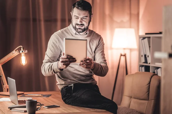 Sorrindo homem assistindo um vídeo em um tablet — Fotografia de Stock