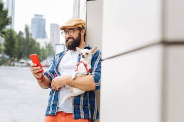 Esmer adam köpeğini sokaklarda yürürken holding