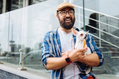 Köpek ile hafta sonu yürüyüş tadını çıkarırken gülen esmer adam