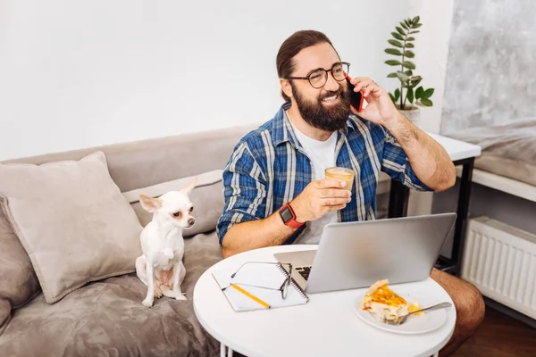Busy successful remote worker smiling while talking on phone