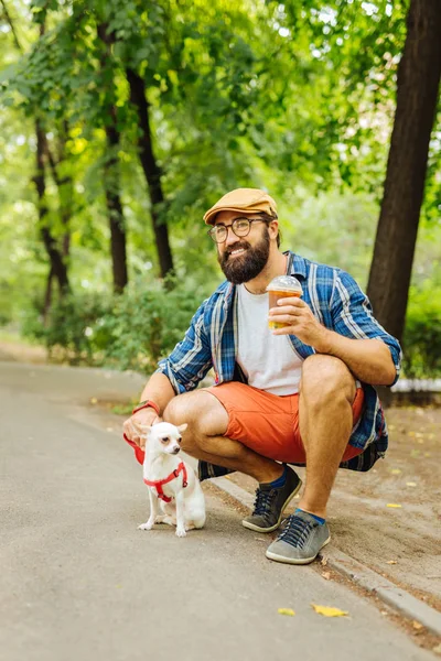 公園で彼の犬を連れて歩いて現代のハンサムな男 — ストック写真
