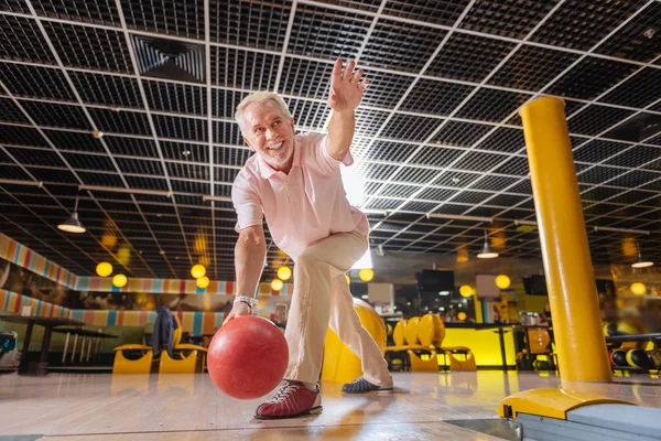 Joyful bom homem idoso jogando boliche e sorrindo — Fotografia de Stock