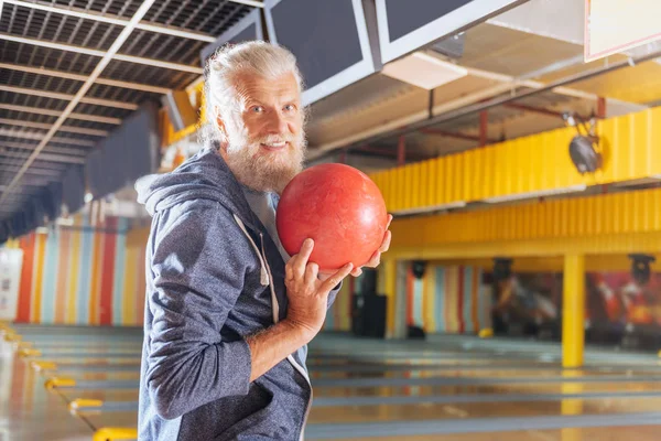Homem barbudo alegre segurando uma bola em sua mão — Fotografia de Stock