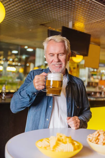 Memnun yaşlı adam masada bira içmek — Stok fotoğraf