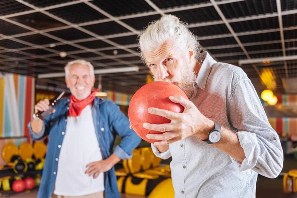 Sério homem idoso beijando a bola de boliche — Fotografia de Stock