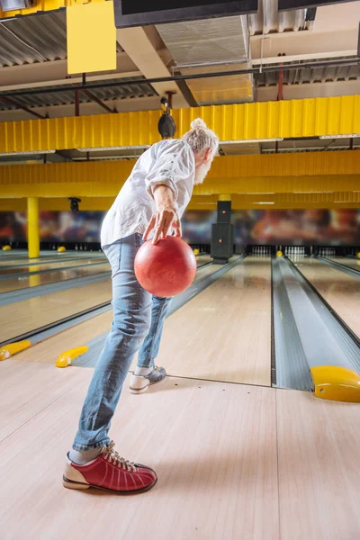 Un vieil homme sérieux se prépare à lancer la balle — Photo