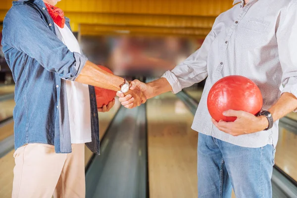 Nahaufnahme eines Handschlags in einem Bowlingclub — Stockfoto