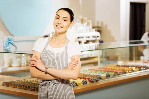 Pastelera positiva de pie con los brazos cruzados y sonriendo —  Fotos de Stock