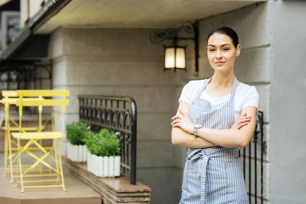 Glada unga servitrisen stående utomhus och leende — Stockfoto