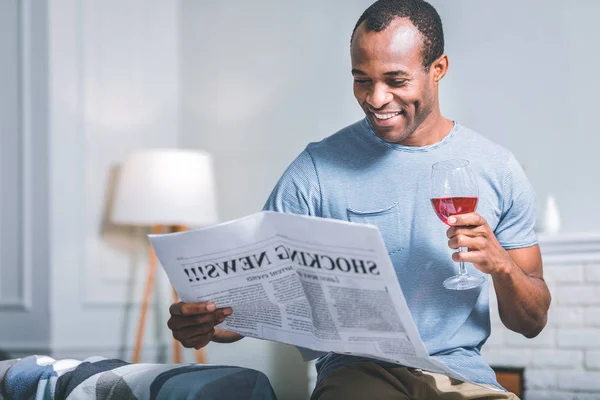 Hombre sonriente leyendo un periódico — Foto de Stock