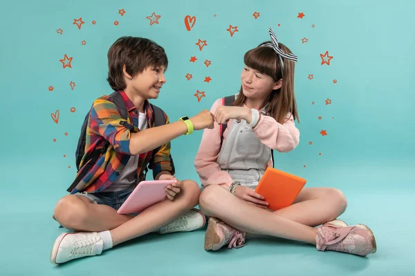 Positive kids putting their fists together and looking happy — Stock Photo, Image