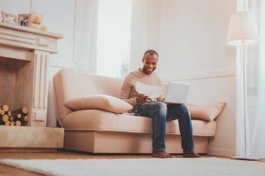 Onun laptop ile kanepede oturan memnun adam