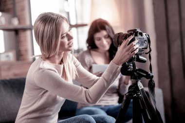 Günün kutlu olsun. Arka planda oturan arkadaşı ise onun video kamera sabitleme coşkulu sarışın kadın