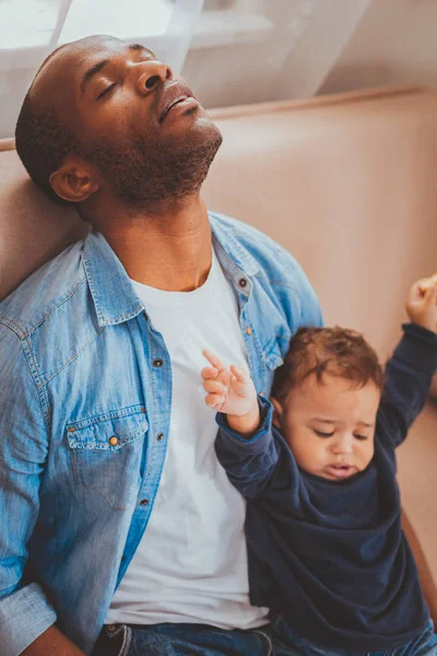 Exhausted father babysitting his child and sleeping — Stock Photo, Image