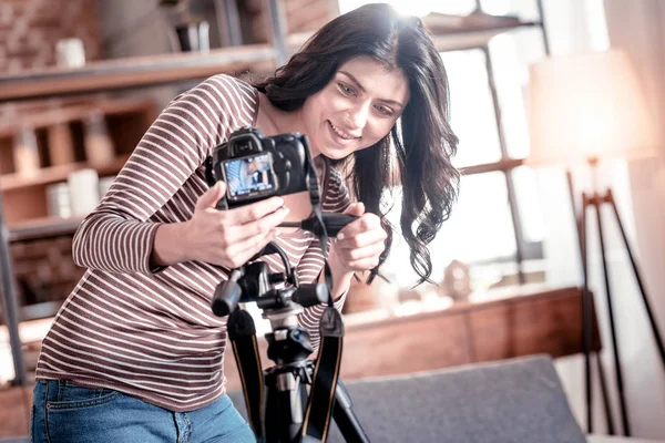 Blogueiro sorrindo consertando sua câmera moderna — Fotografia de Stock