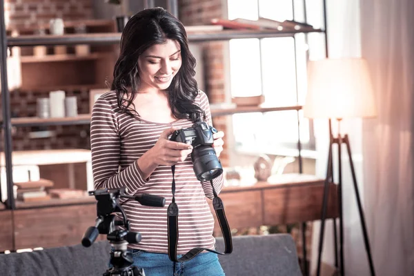 Femme de contenu regardant à travers des photos sur sa caméra — Photo