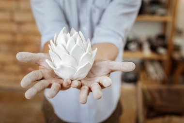 Handy man atölyesinde güzel kil çiçek ayakta tutan