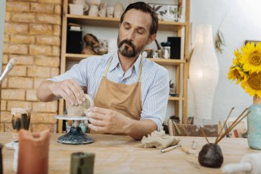 Güzel büyük kil Kupası oluşturan ciddi sakallı potter