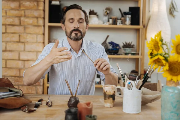 Hombre creativo de pelo oscuro buscando inspiración en su taller — Foto de Stock