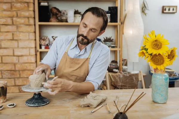 Vidám handicraftsman dolgozik, közel a váza, napraforgó — Stock Fotó