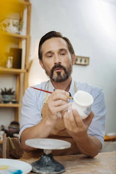 Dark-eyed bearded ceramist wearing apron and working — Stock Photo, Image