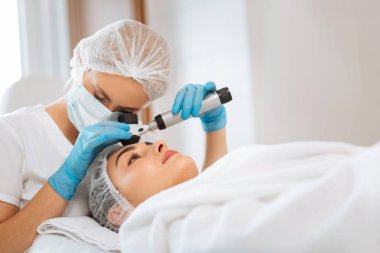 Dermatoscope bakarak akıllı profesyonel doktor