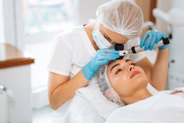 Yetenekli kadın dermatolog cilt sınav yapıyor