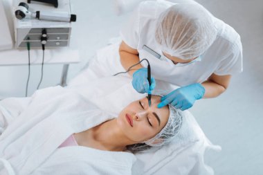 Akıllı yetenekli güzellik uzmanı bir köstebek lazer tedavisi ile kaldırma