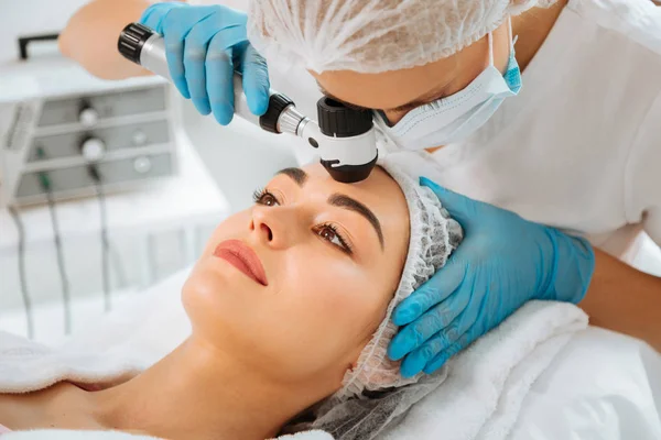 Dermatóloga femenina cualificada que utiliza equipos profesionales modernos — Foto de Stock