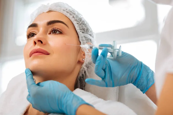 Positive nice woman having an injection in the cheek — Stock Photo, Image