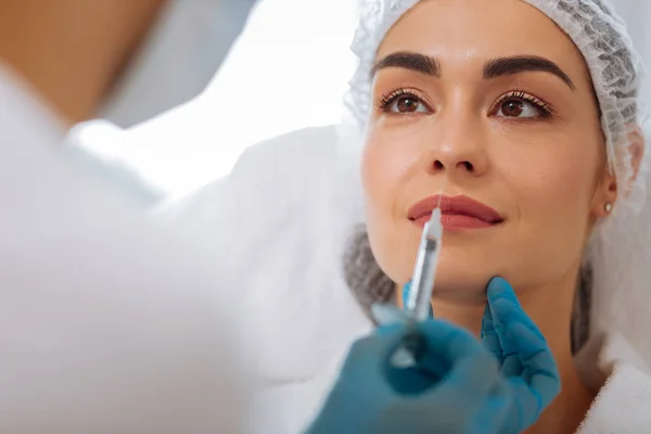 Nice pleasant woman looking at her cosmetologist — Stock Photo, Image