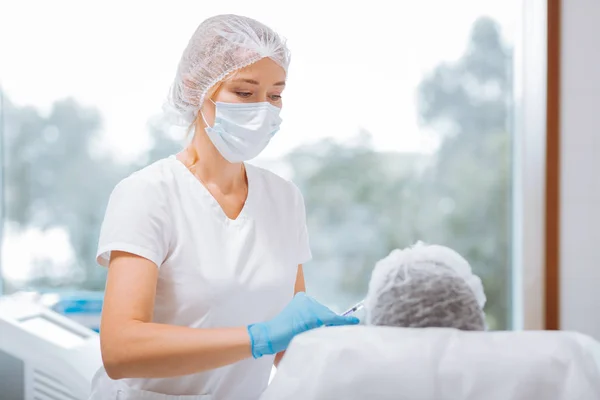 Cosmetólogo experto profesional mirando a su cliente — Foto de Stock