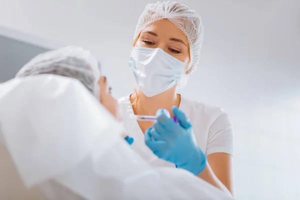 Smart professional female cosmetologist wearing a mask — Stock Photo, Image