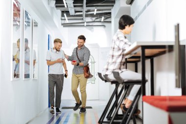 İki arkadaş bir akıllı telefon ekranına bakarak yürüyüş