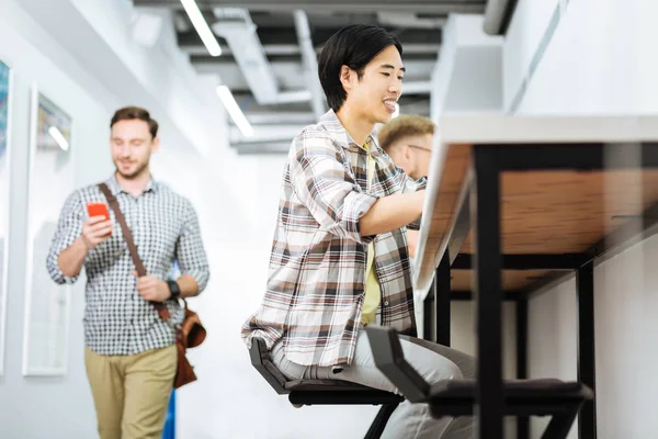 Üç kişi cihazlar ile coworking alanı ziyaret ederken işgal